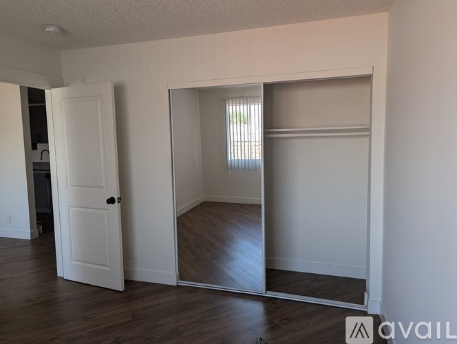 A room with a white door and a mirror on the wall.