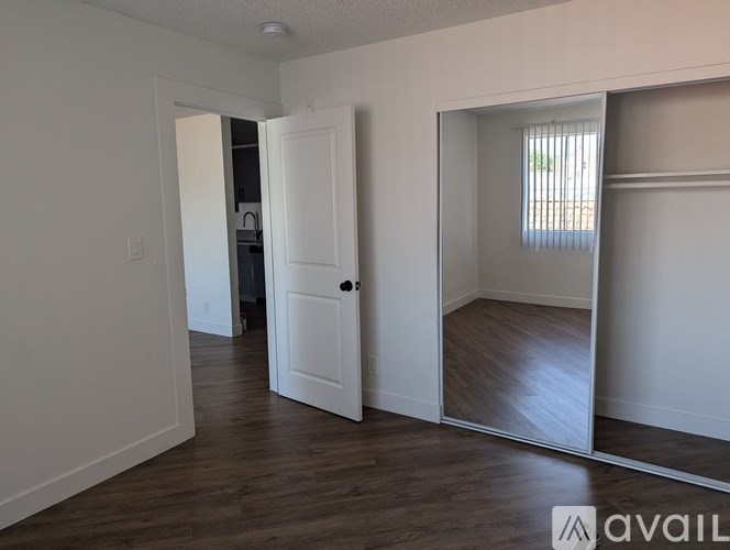 A room with a white door and a mirror on the wall.