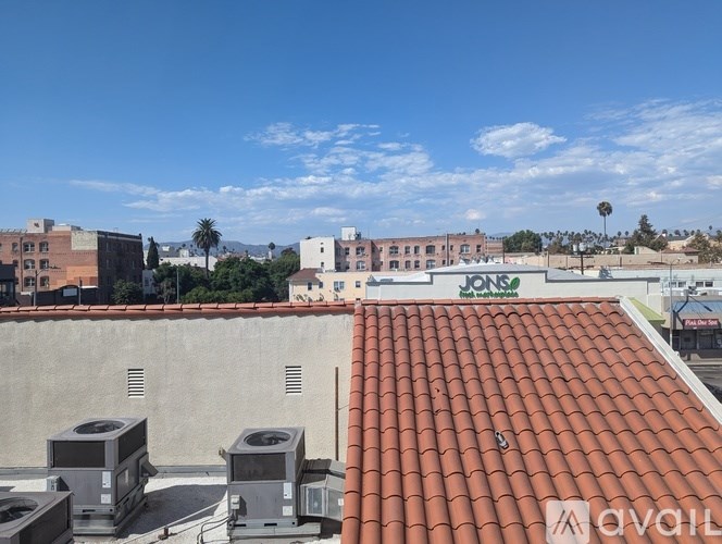 A rooftop with a red tile roof and air conditioning units.