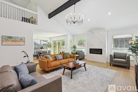 A living room with a fireplace and a large painting on the wall.