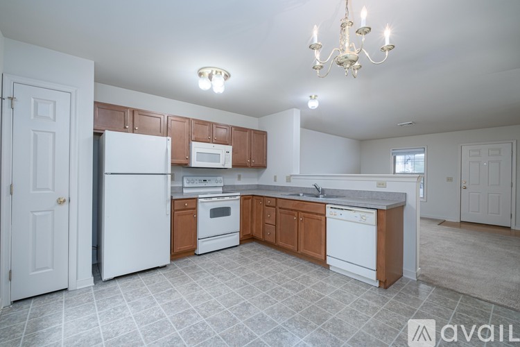 A kitchen with white appliances and wooden cabinets.