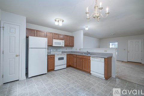 A kitchen with white appliances and wooden cabinets.