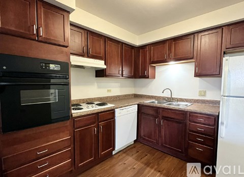A kitchen with brown cabinets and a black oven.