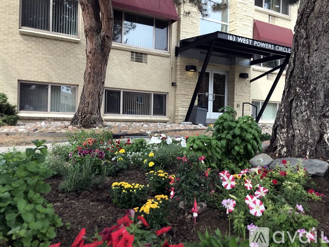 A flower bed in front of a building with the sign "163 WEST POWERS CIRCLE".