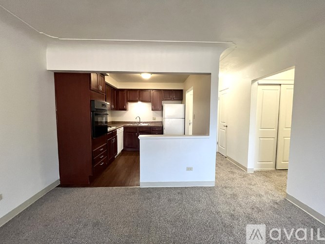 A kitchen with brown cabinets and a white fridge is available.