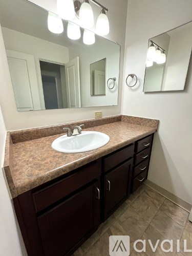A bathroom with a sink and brown countertop.