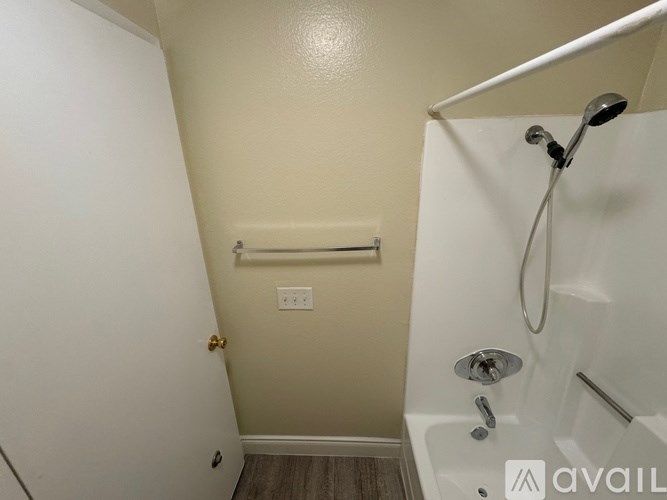 A bathroom with a white tub and a shower head.