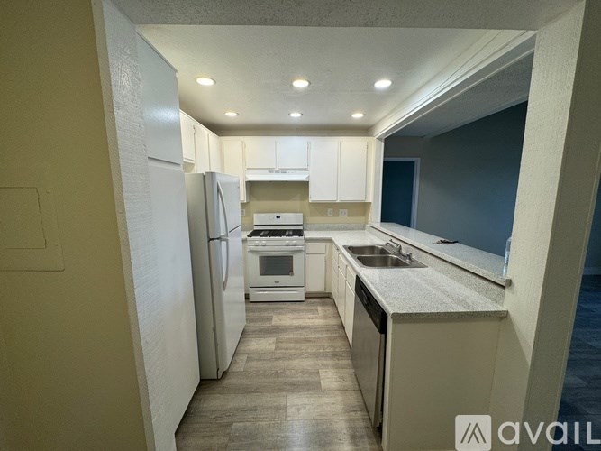 A kitchen with a refrigerator, sink, and stove.
