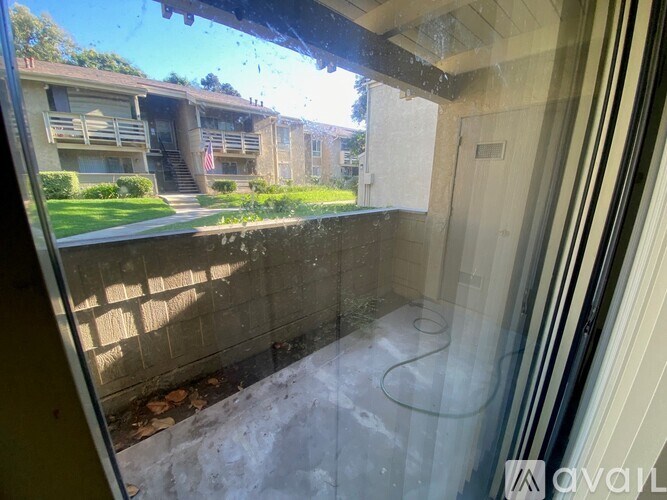 A view from inside a room looking out to a building with a flag on it.