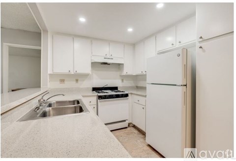 A kitchen with white cabinets and appliances.