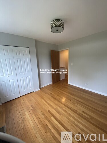 A room with wooden flooring and a white door is available for rent.