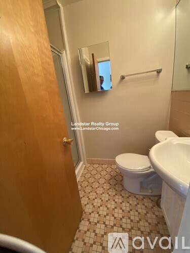 A bathroom with a toilet, sink, and mirror.