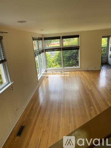 A room with wooden floors and large windows.