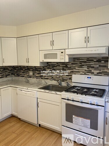 A kitchen with white cabinets and a stove top oven.