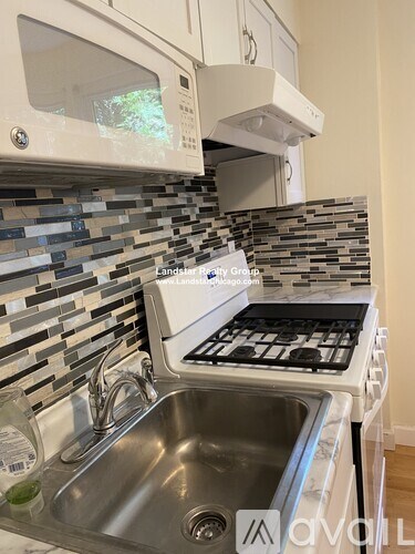 A kitchen with a stove top oven and a microwave above it.