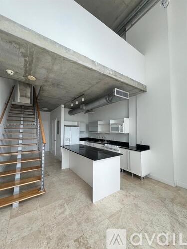 A kitchen with a black countertop and white cabinets is available for rent.