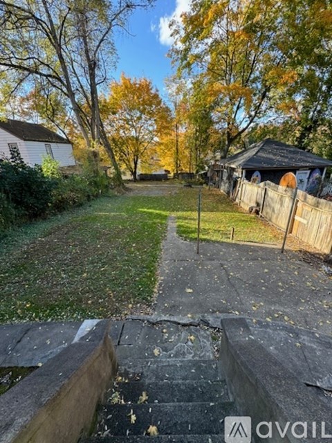 A backyard with a wooden fence and a small gazebo.