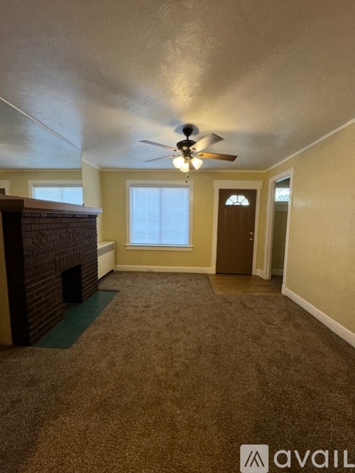 A room with a fireplace and a ceiling fan.