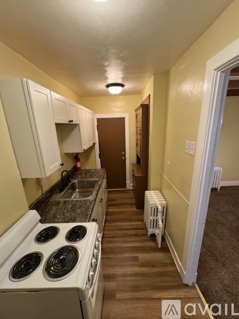 A kitchen with white cabinets and a stove top oven.