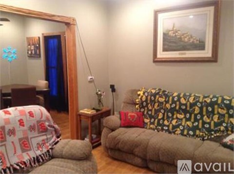 A living room with a couch, chair, and a painting on the wall.
