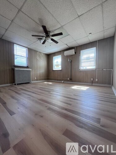 A room with wooden floors and a ceiling fan.