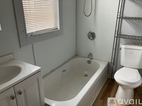 A white toilet is next to a bathtub in a bathroom.