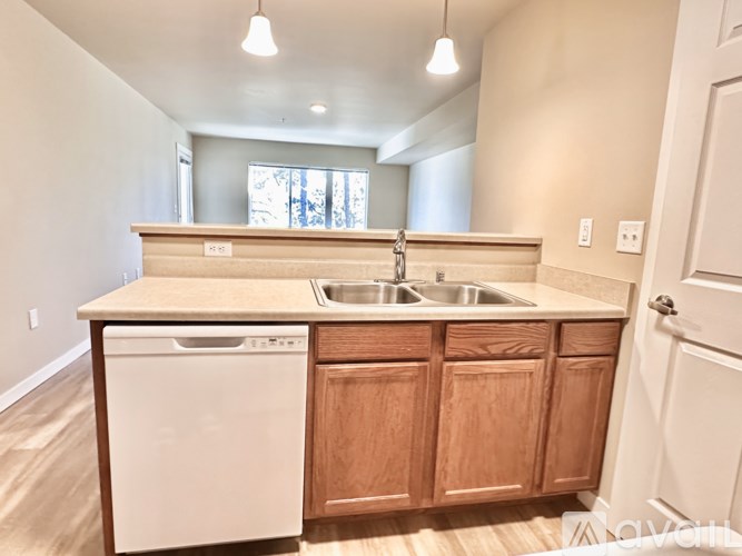 A kitchen with wooden cabinets and a white dishwasher.