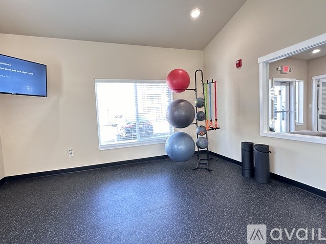 A room with a blue screen on the wall and exercise equipment.