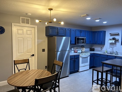 A kitchen with blue cabinets and a stainless steel refrigerator.