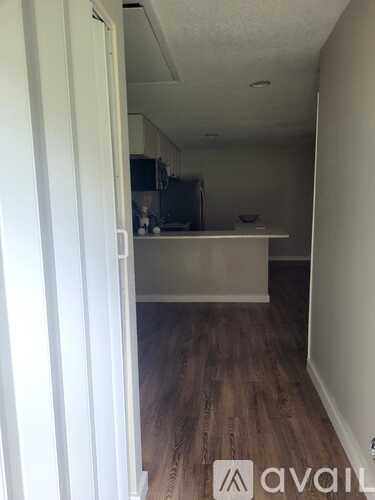 A black fridge and freezer in a kitchen with white cabinets.