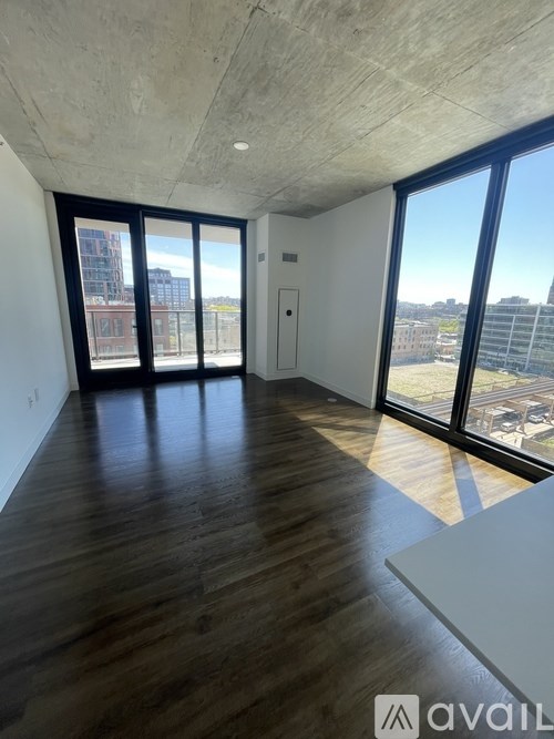 A room with wooden floors and large windows overlooking a cityscape.