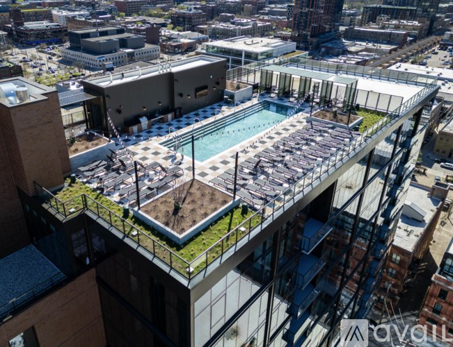A rooftop garden with a pool and a green lawn.