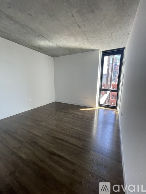 A room with wooden flooring and a large window.