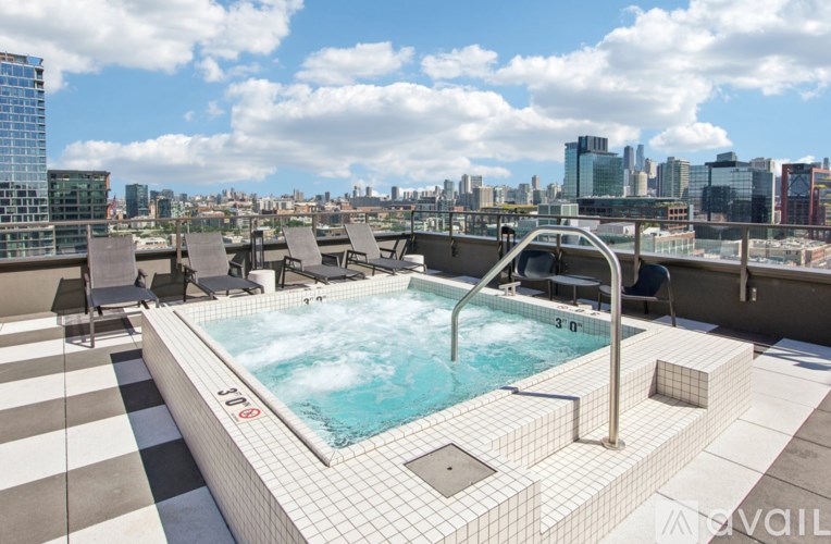 A hot tub on a rooftop with a cityscape in the background.