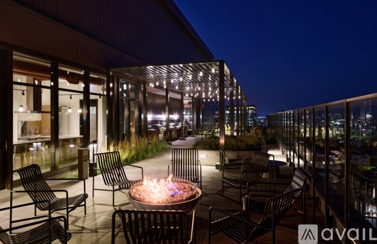 A patio with chairs and a table with a lit candle in the middle.