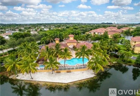 A resort with a pool surrounded by palm trees.