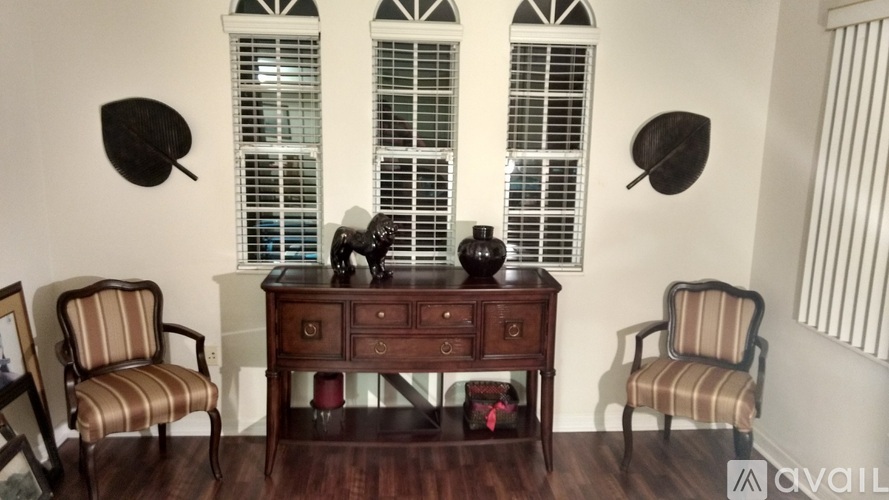 A wooden desk with a chair on each side and two decorative objects on top.