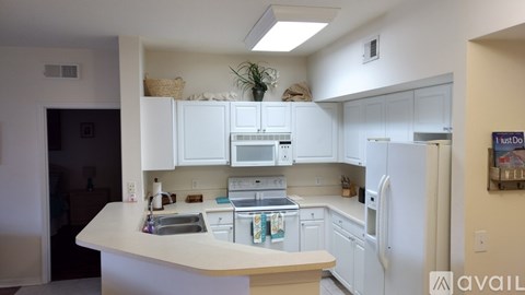 A kitchen with white cabinets and appliances.