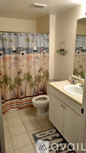 A bathroom with a toilet, sink, and shower curtain.