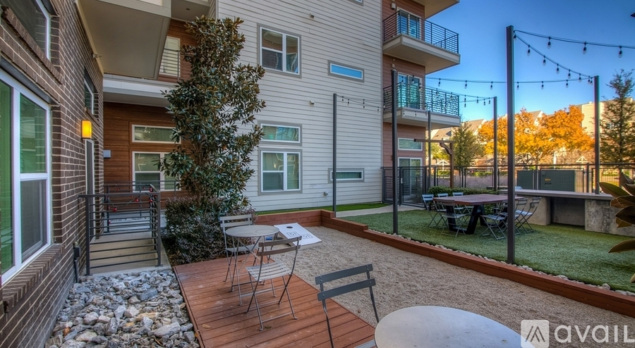 A balcony with a table and chairs is attached to a house.