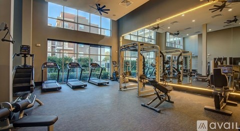 A gym with a variety of equipment including treadmills, weights, and exercise machines.