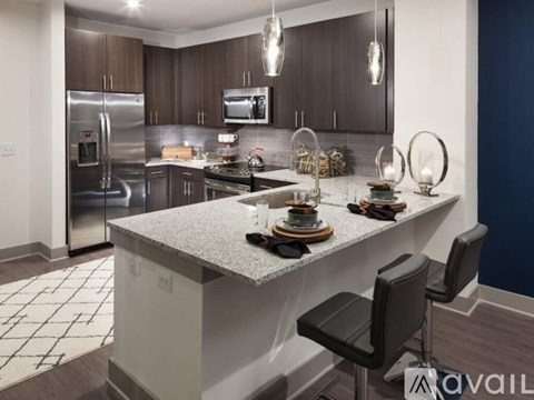A modern kitchen with a large island and stainless steel appliances.