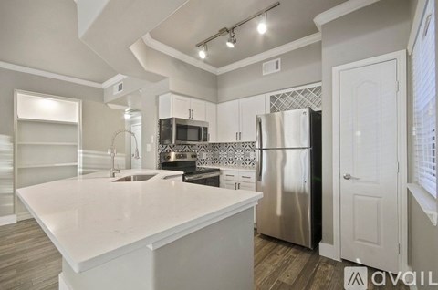 A kitchen with a white countertop and stainless steel appliances.