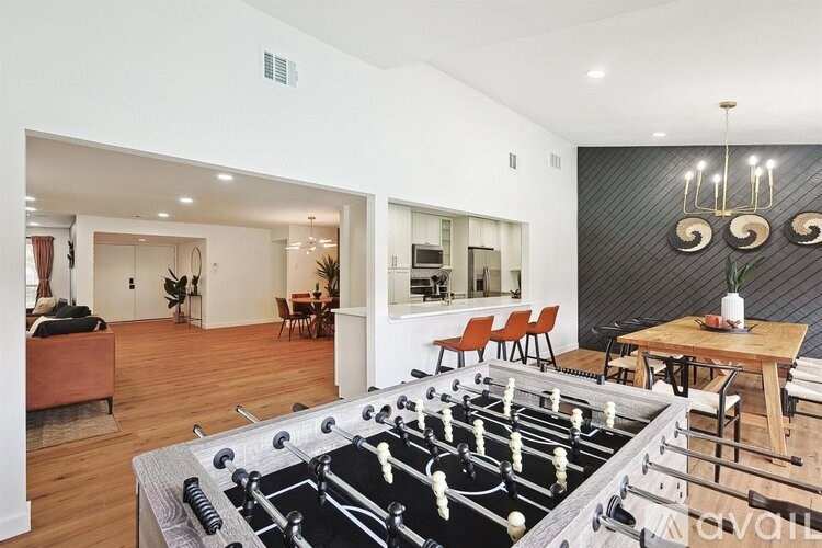 A foosball table is in the middle of a living room.