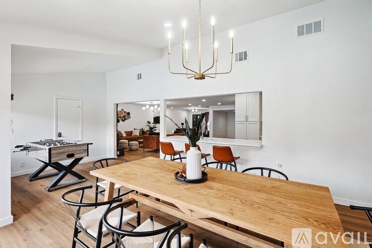 A modern dining room with a wooden table and chairs.