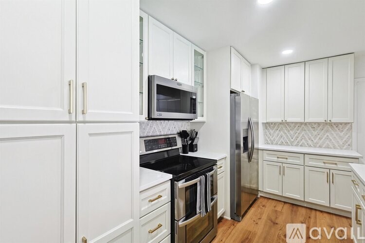 A kitchen with white cabinets and a black countertop.