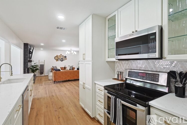A kitchen with a white counter top and a black stove top oven.