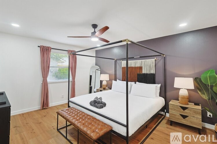 A bedroom with a four poster bed and a ceiling fan.