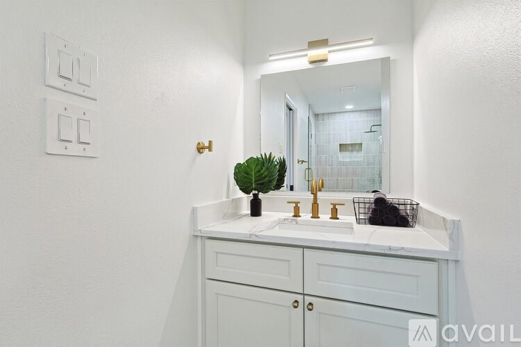A bathroom with a white countertop and a mirror above it.