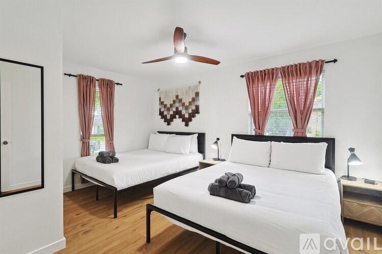 A bedroom with two beds and a ceiling fan.